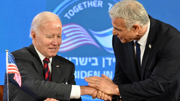 US President Joe Biden (L) and Israel's caretaker Prime Minister Yair Lapid speak to each other after signing a security pledge in Jerusalem, on July 14, 2022.